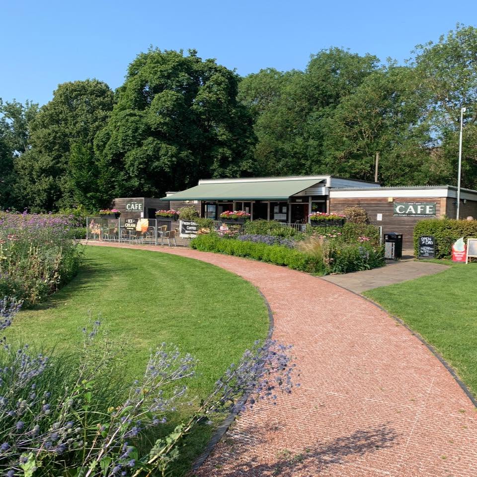 Central Park Cafe beside a curving park path, surrounded by trees